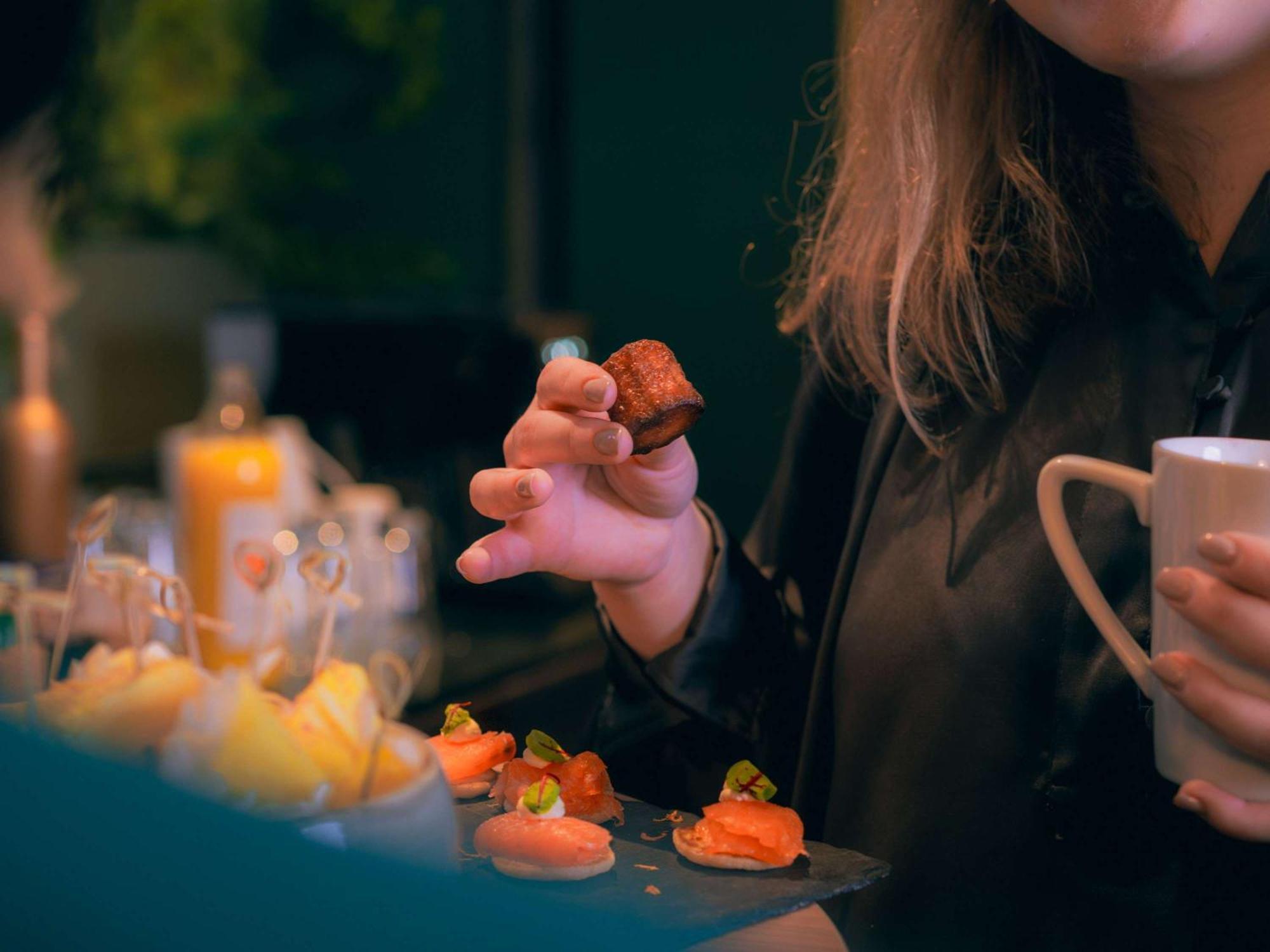 Nest Paris La Defense - Mgallery Puteaux Dış mekan fotoğraf A woman holding a piece of sushi